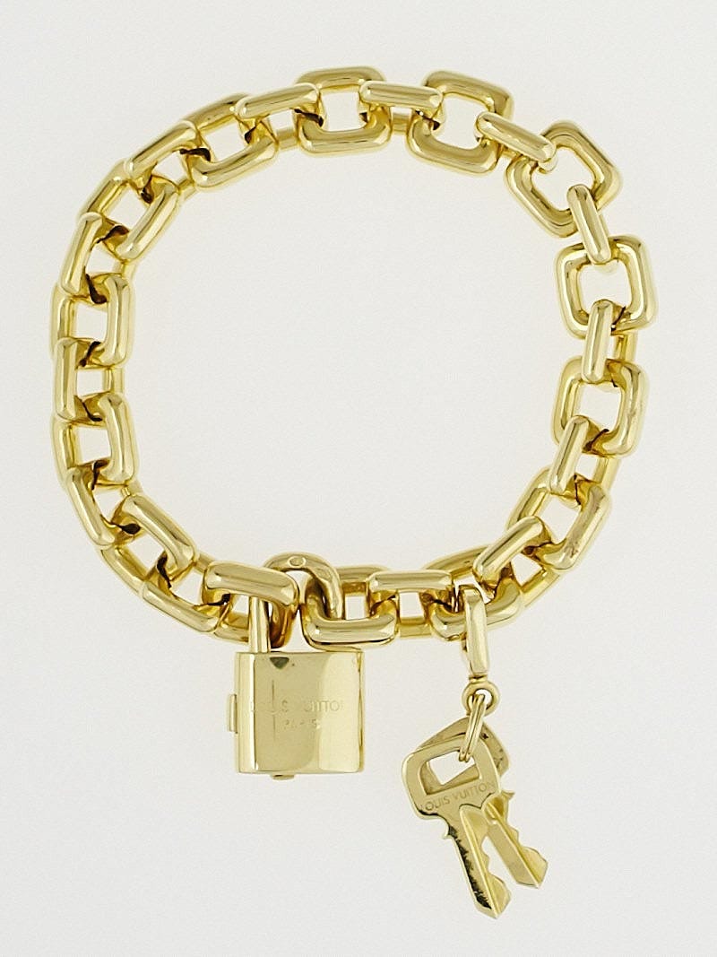 The Louis Vuitton padlock and key charm bracelet in white gold.